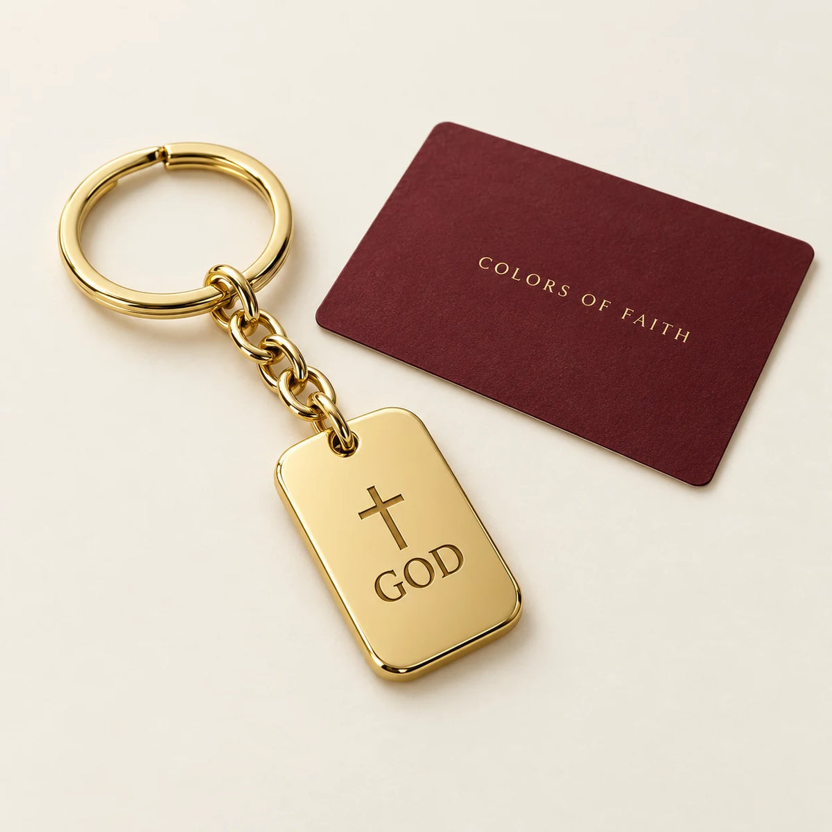 Gold-tone God keychain with a cross and burgundy presentation card